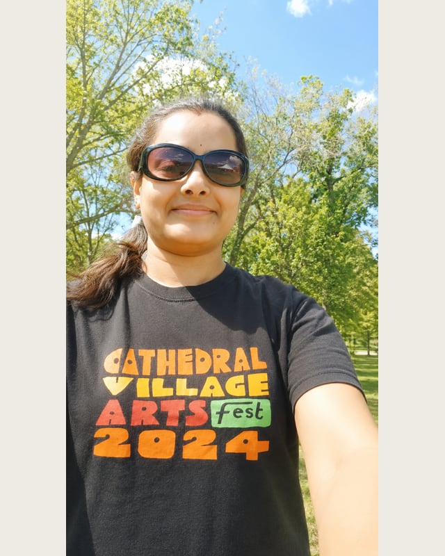 Hemamalini Venkataraman fait du bénévolat à l’extérieur en portant un chandail du Cathedral Village Arts Festival 2024.