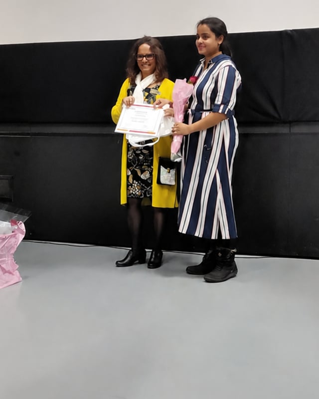 Hemamalini Venkataraman remet des fleurs et un certificat lors d’une activité communautaire.